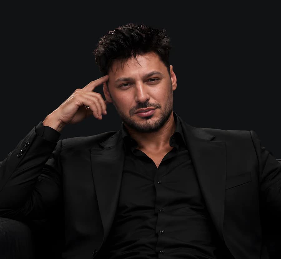 Lex Mareș seated in a dark chair, portrait